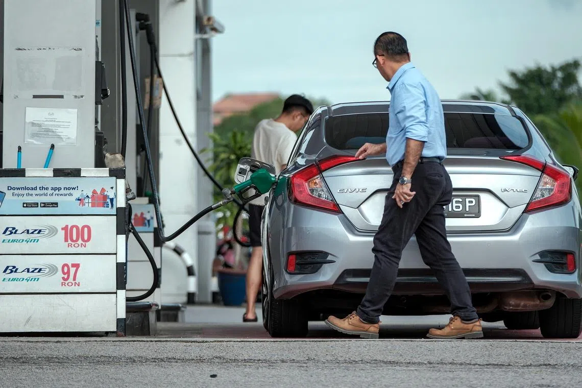 一辆新加坡车在新山一家油站添加RON97汽油（绿色油枪）。