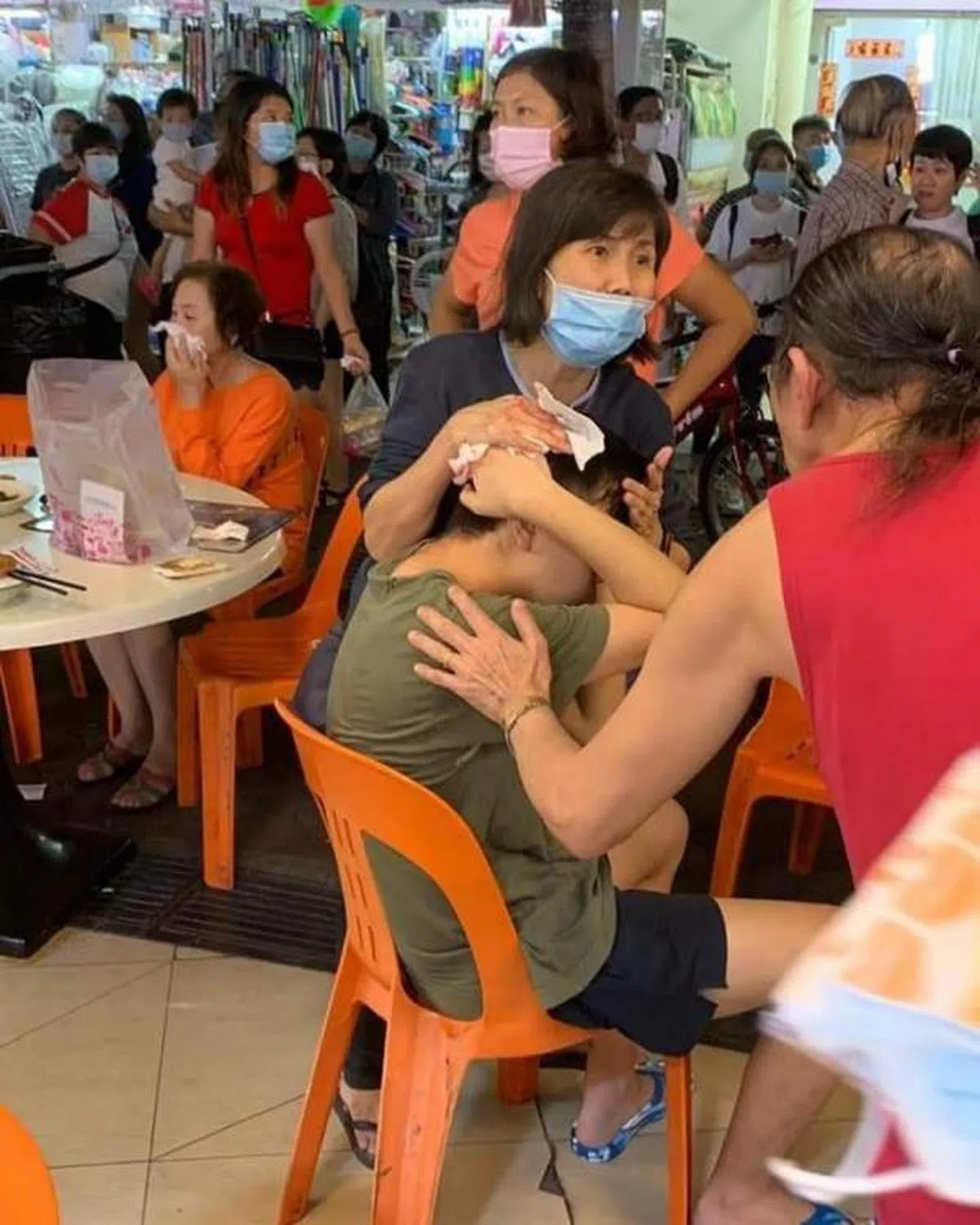  有热心民众为受伤的青年捂着伤口，试图替他止血。（家在新加坡 Singapore Our Home面簿） 