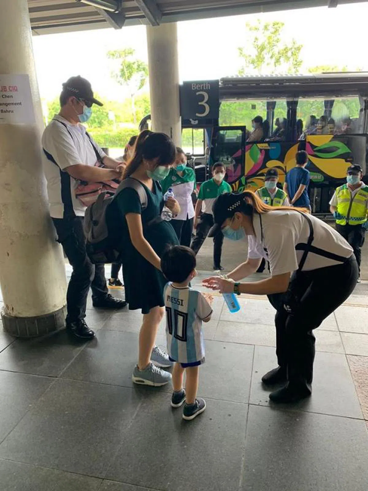  圣约翰机构人员为准备登上巴士的孕妇和小孩测量体温。（曾茄恩面簿） 
