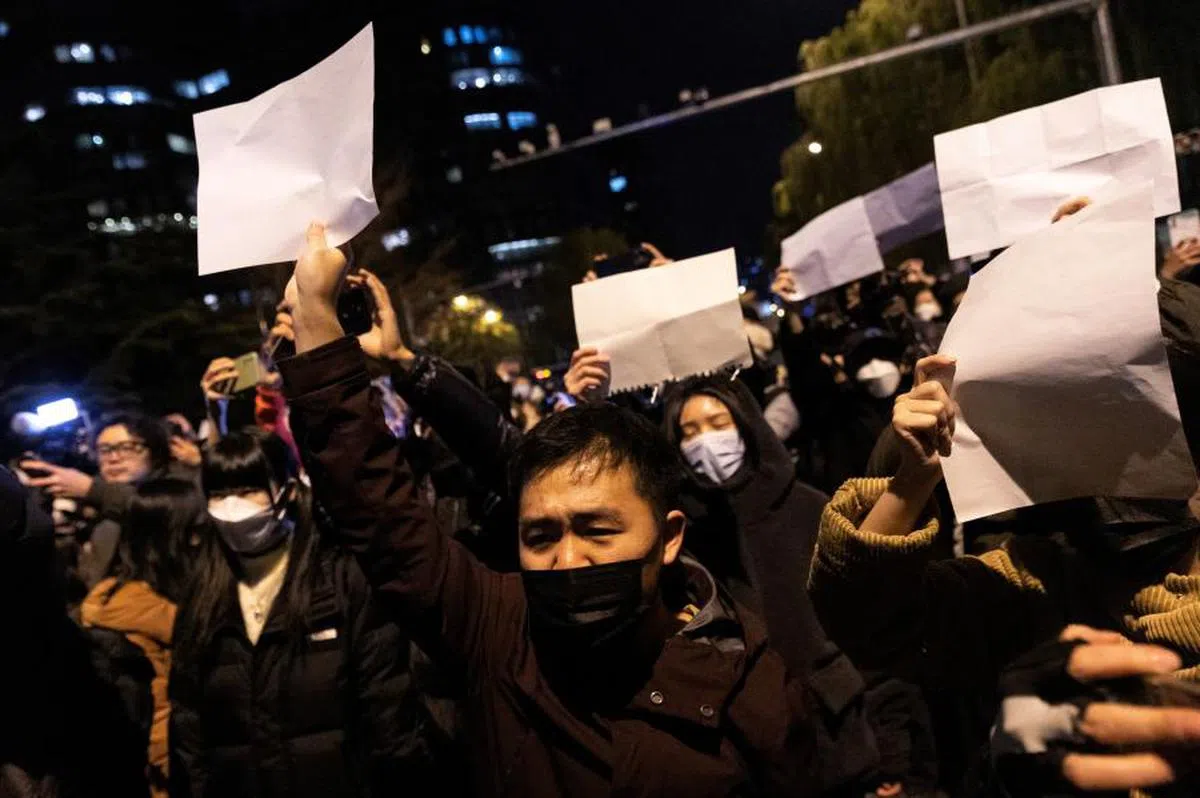 北京民众在街上高举白纸抗议当局的防疫政策。（路透社）