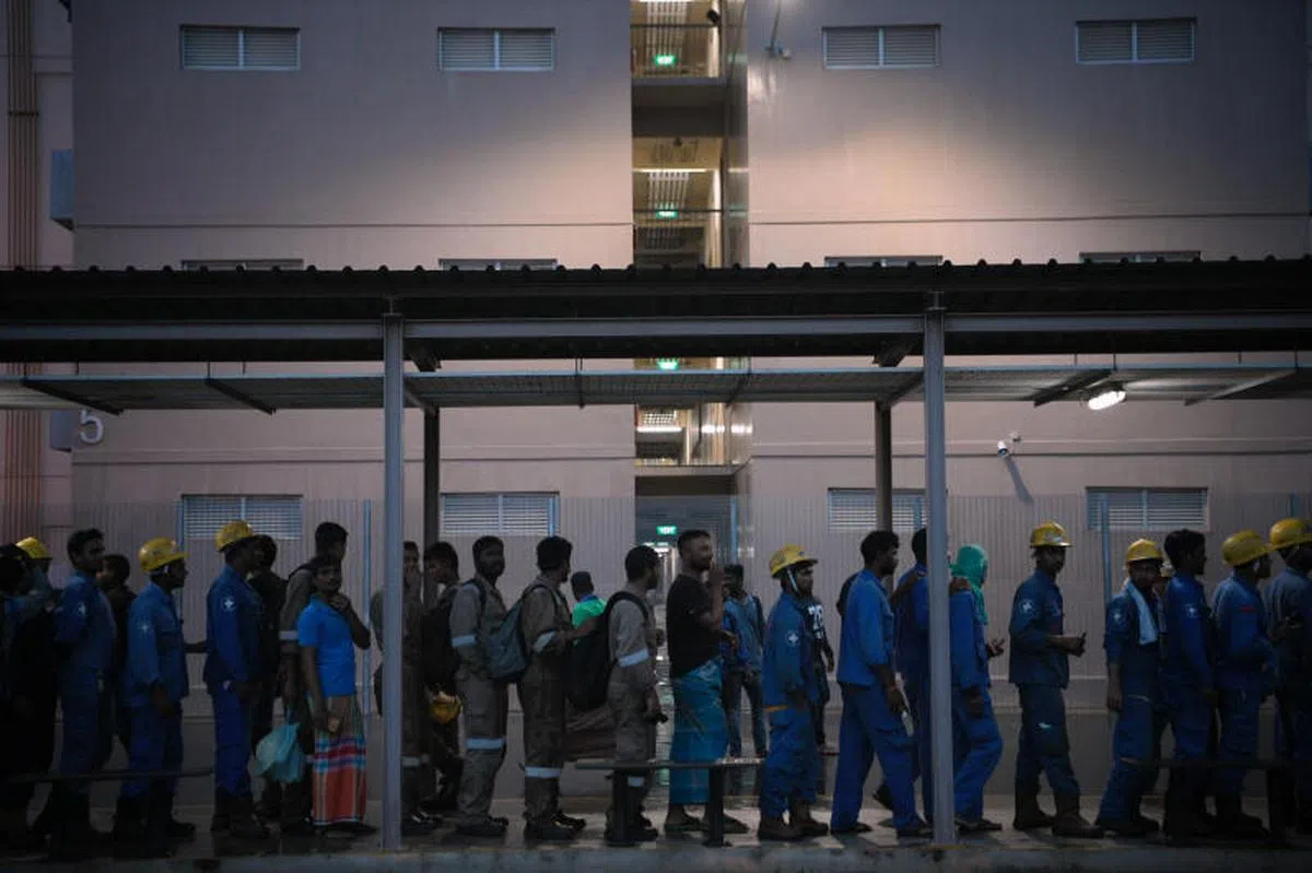  劳累工作了一天回返宿舍的客工们。（海峡时报） 