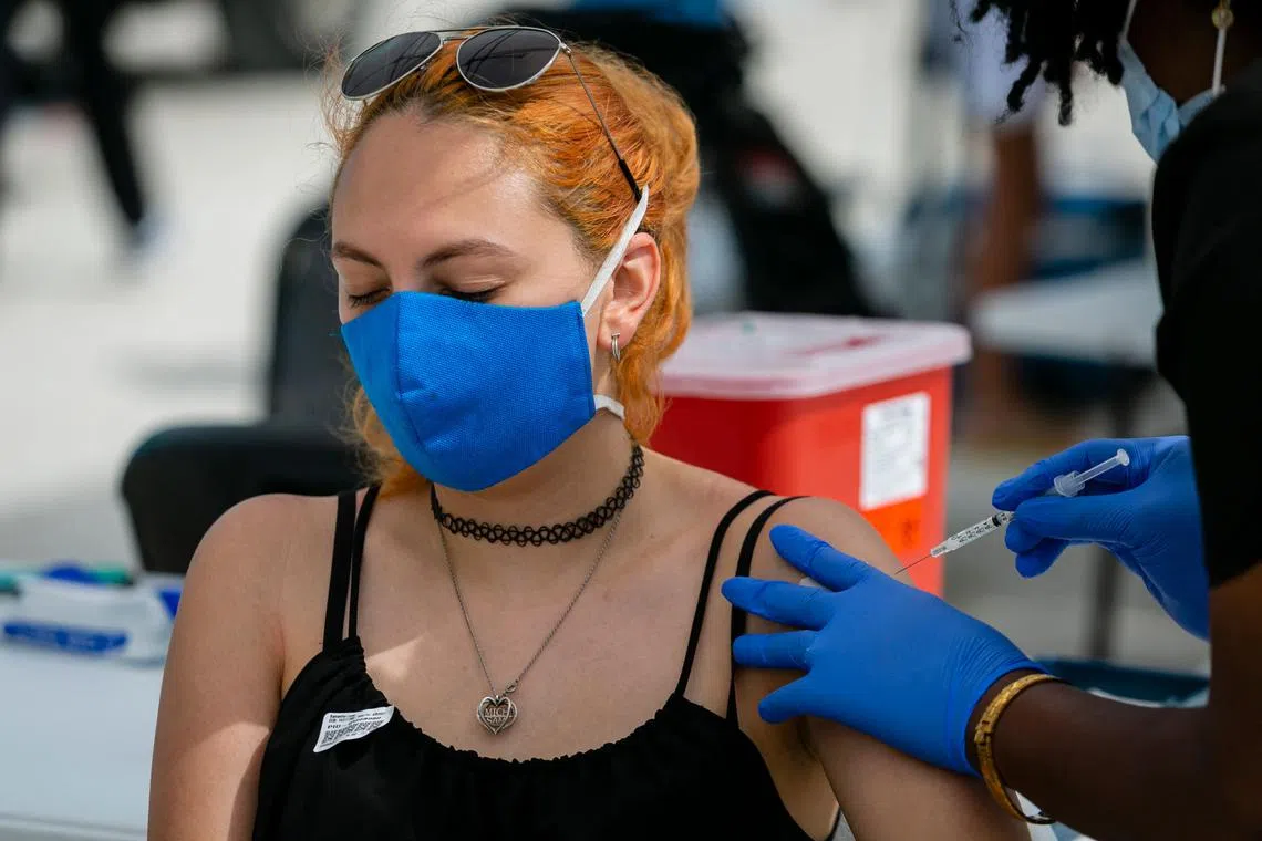 一名女子正在佛罗里达州一处海滩的疫苗接种据点打疫苗。（法新社）