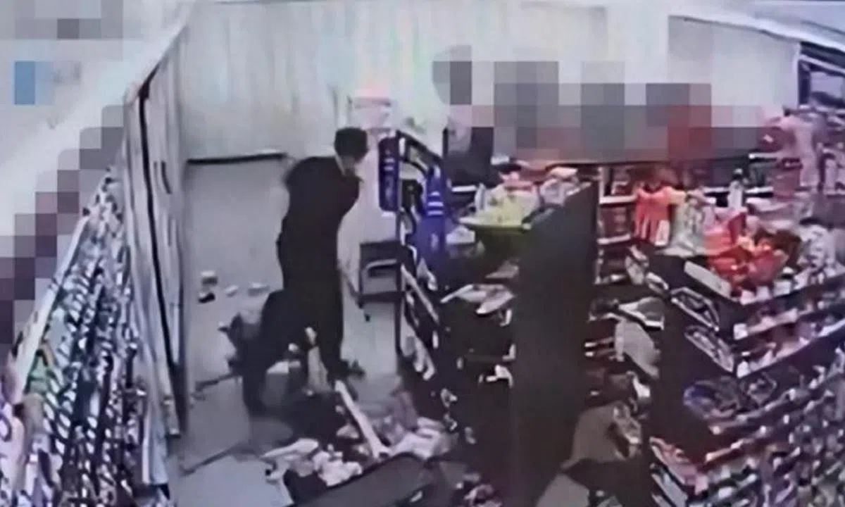 便利商店监控画面显示，喝醉的男顾客在深夜闯入店内，对女店员拳打脚踢。（韩国中央日报）