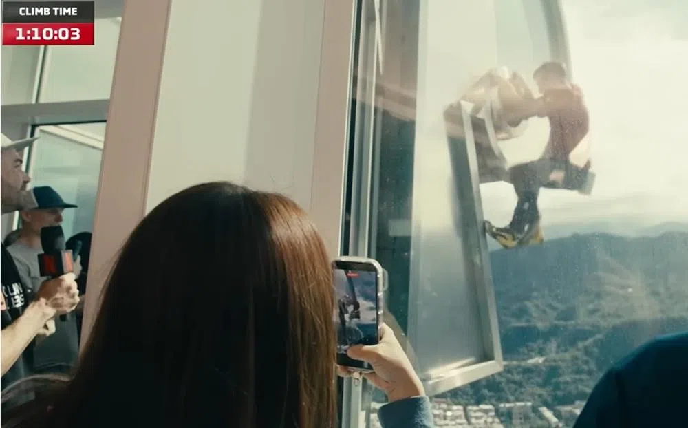 霍诺德攀爬之际，大楼内的公众拿起手机拍摄。