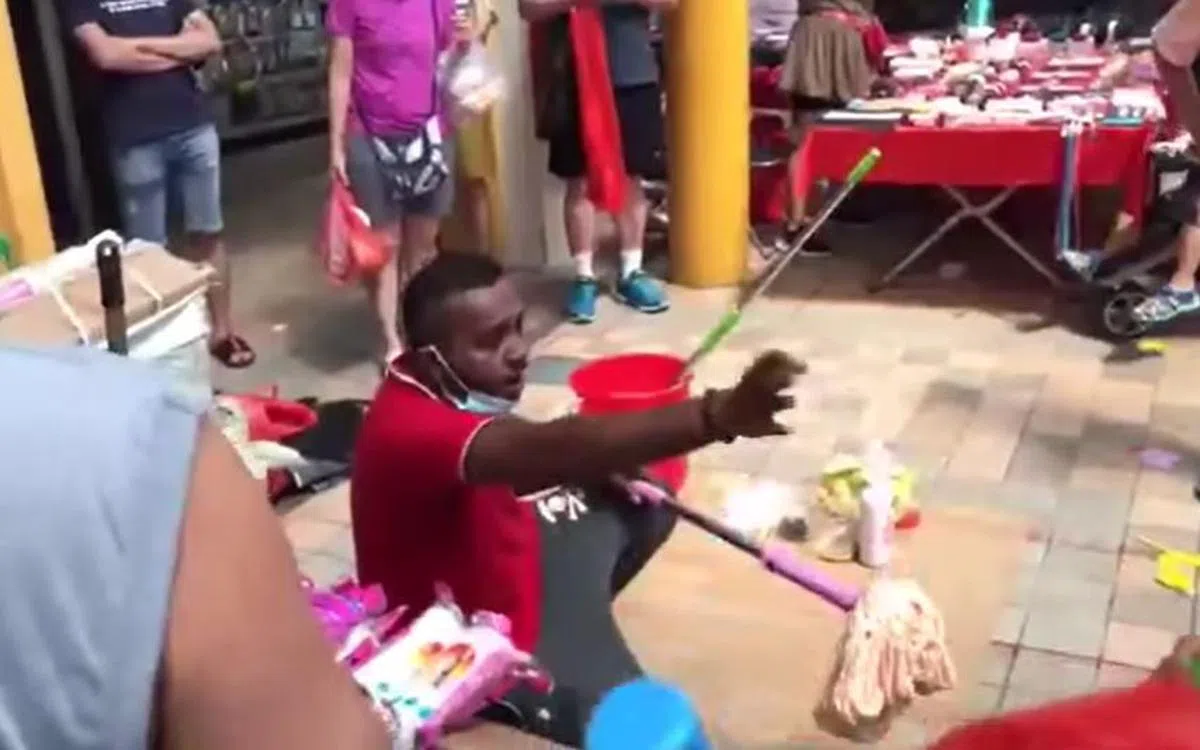  不少“没耐心”的民众掏出钱财，准备购买印族男子售卖的拖把。（视频截图） 