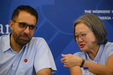 摄影记者捕捉到工人党秘书长毕丹星（左）和党主席林瑞莲（右）在该党第二场准候选人介绍会上的这一幕，不知他们是否在盘算着什么？（海峡时报）