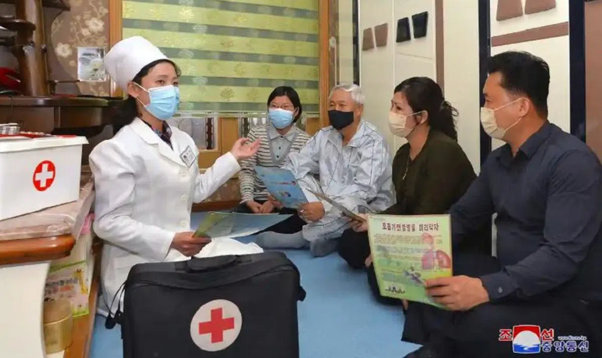 朝鲜医护人员登门拜访，提高朝鲜人民对冠病病毒的认识。（朝鲜通信社）