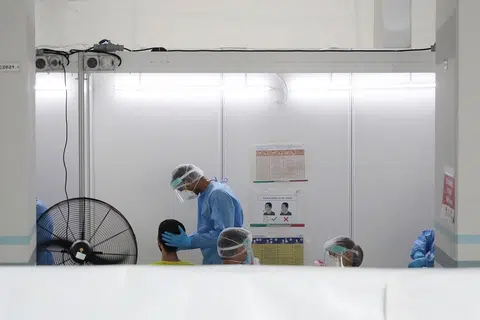 卫生部在2021年5月21至22日为后港8道第506座组屋的405人进行冠病检测，图为一位居民正在接受采检。（联合早报）