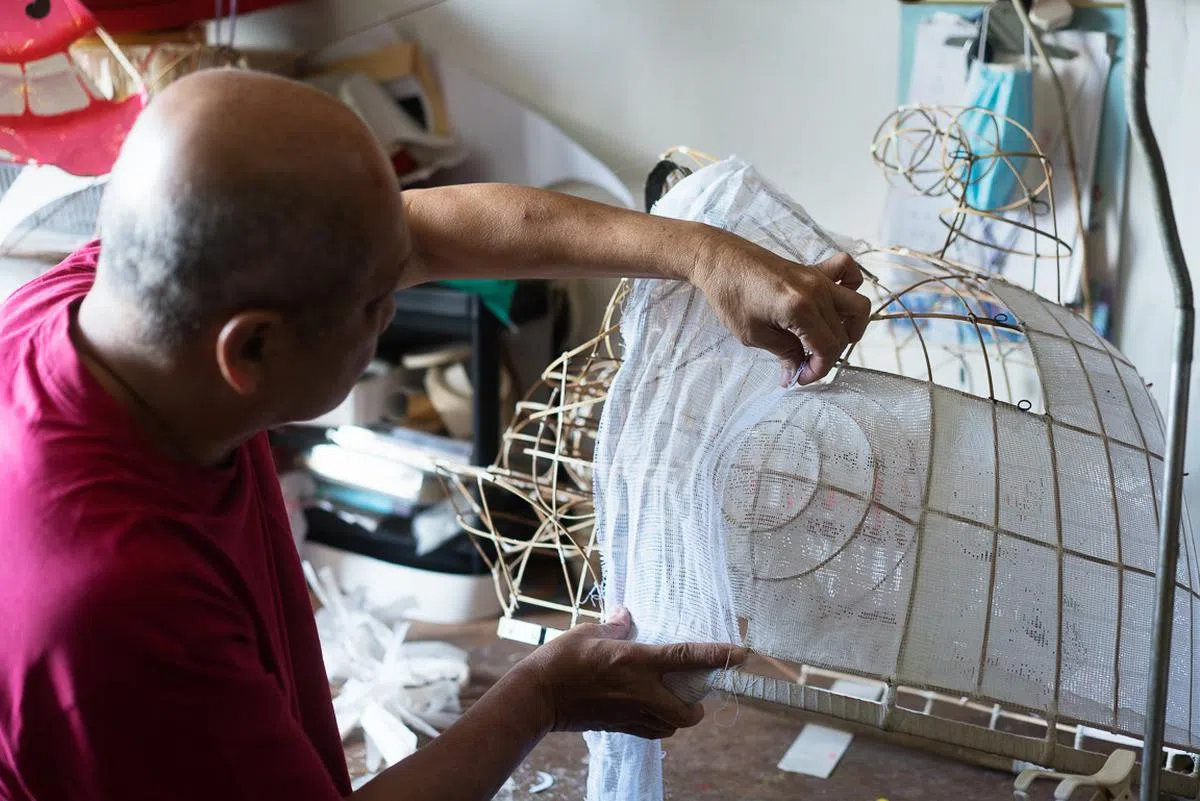 在狮头骨架上粘上浆糊的纱布为扑。（蔡家增摄）