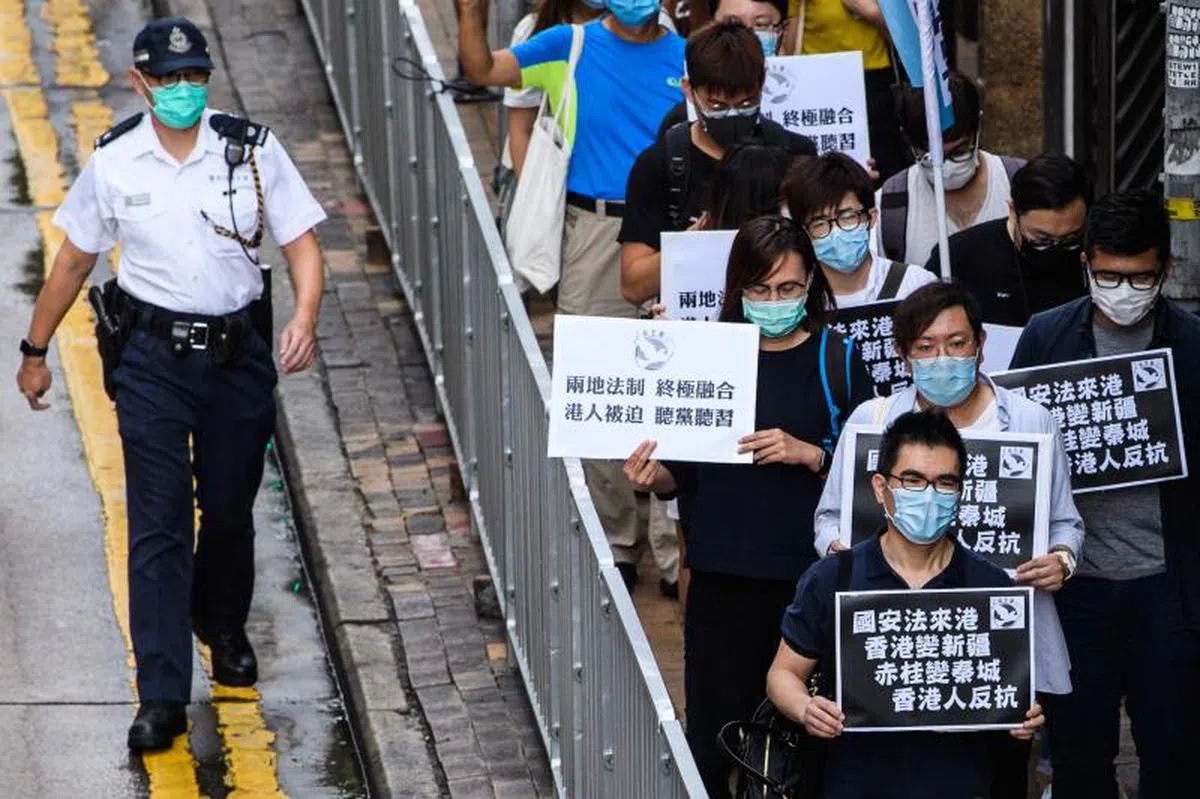  2020年5月22日香港街头的抗议民众手中都举了牌子反对最新的港版国安法。（法新社） 