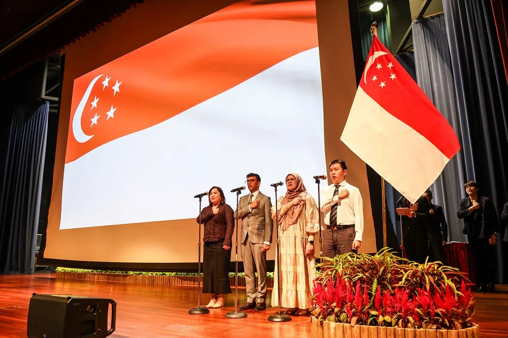 根据国家人口及人才署发布的《2024年人口简报》，2023年有2万3472人获得新加坡公民权，而同年出生的公民婴儿只有2万8877名。图为今年3月几位新公民在德义区新公民宣誓仪式上宣读新加坡信约。（联合早报）