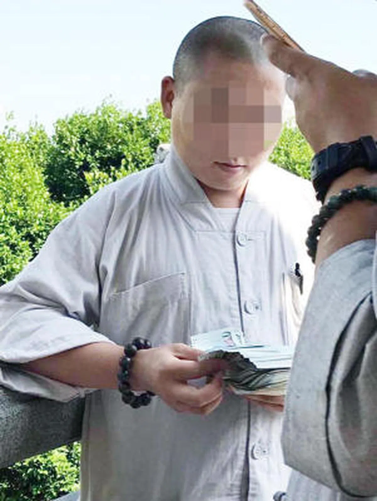  手持厚厚的钞票数着。（新明日报） 