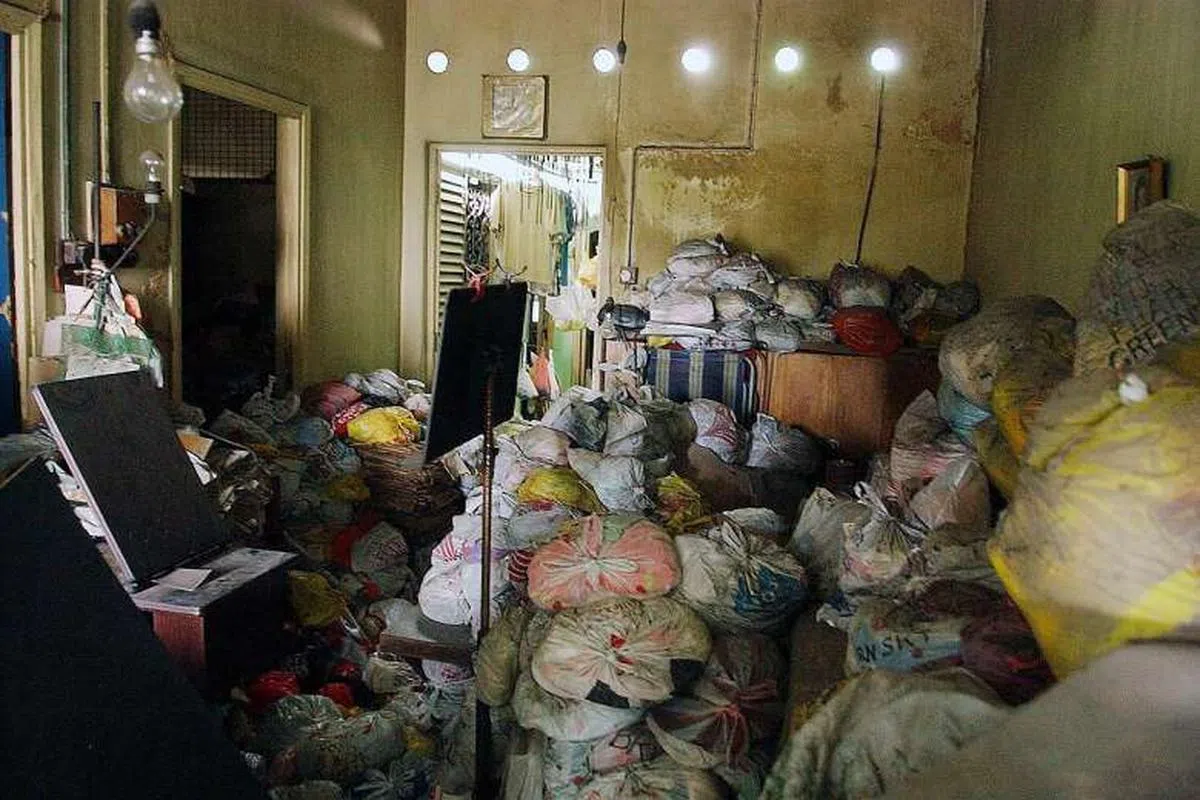  《海峡时报》记者在2006年7月进入屋内，发现客厅中囤积了大量装满衣服的塑料袋。（海峡时报） 