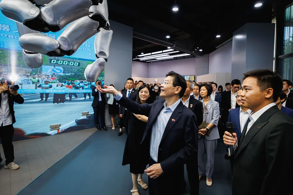 黄循财总理（前排左）在上任后的首次访华行程中参观北京人形机器人创新中心，了解中心的尖端科研工作。（数码发展及新闻部）