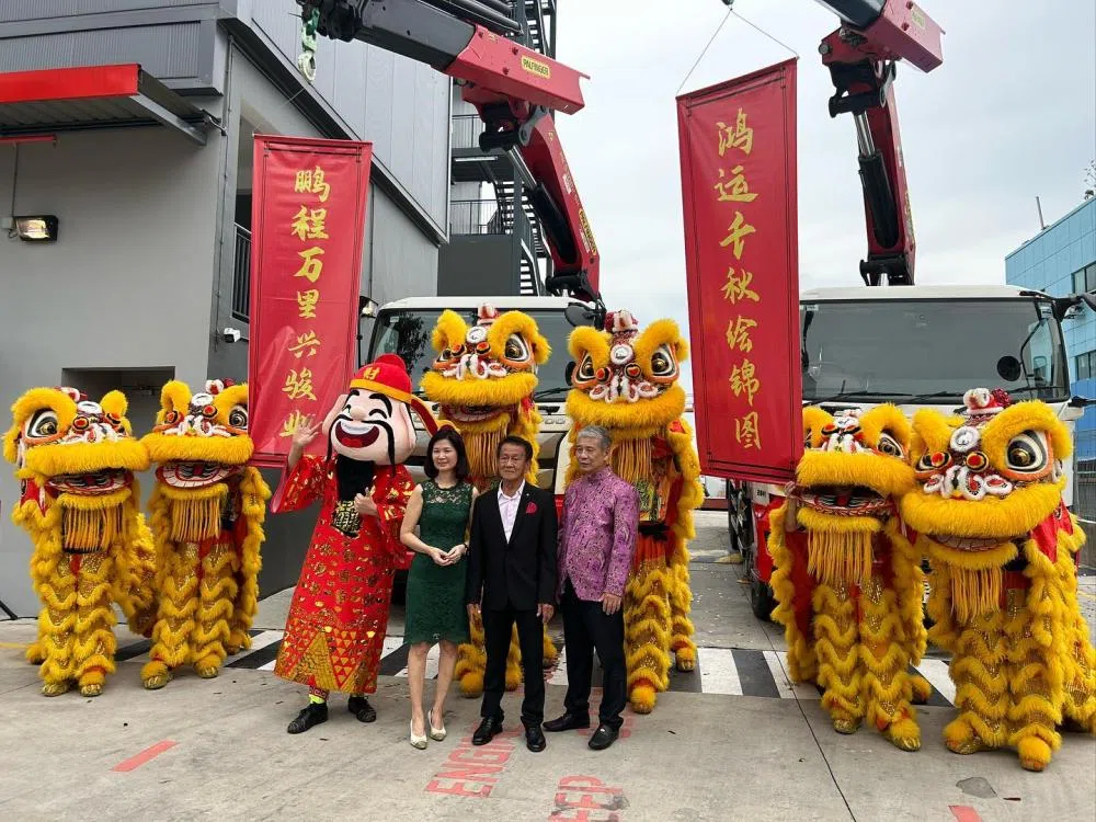 2023年的农历新年，洪嘉汕（中）和妻子戴玉莲（左一）在公司合照留念。（取自Pollisum脸书）