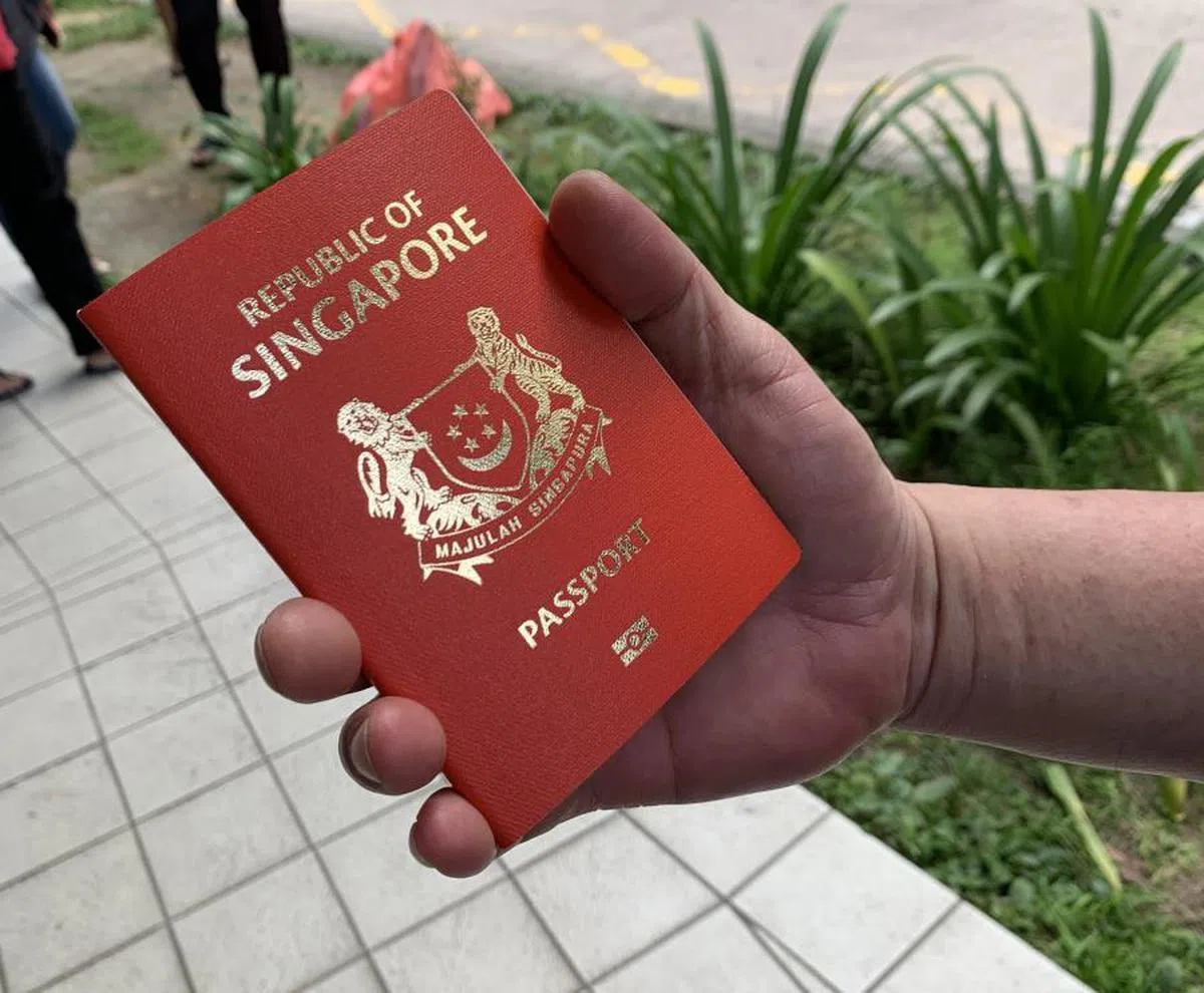 终于领取到新护照的国人。（新明日报）