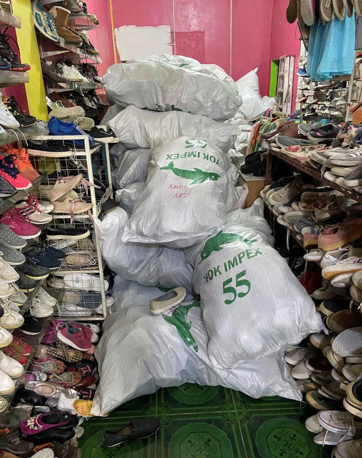 峇淡岛一家鞋店堆满了上头印着“Yok Impex”，里头装着旧鞋的袋子。（路透社）