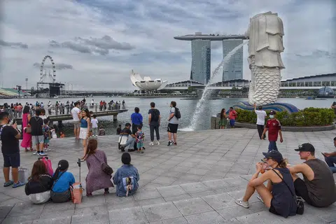 鱼尾狮公园是中国旅客来新加坡必打卡的地点，图为各国旅客在鱼尾狮公园欣赏滨海湾金沙的风景。（海峡时报）