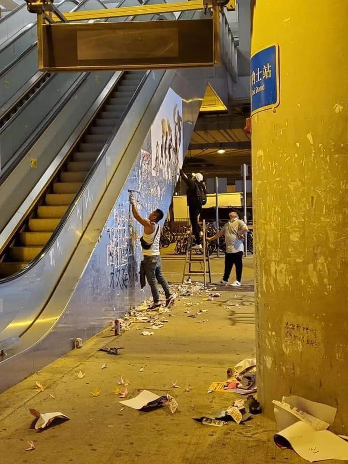  市民主动帮忙将贴在手扶梯上的纸张给清理干净。（我爱旅行面簿） 