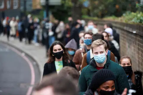 奥密克戎已成为英国伦敦的主流毒株，图为排队施打疫苗的当地民众。（路透社）