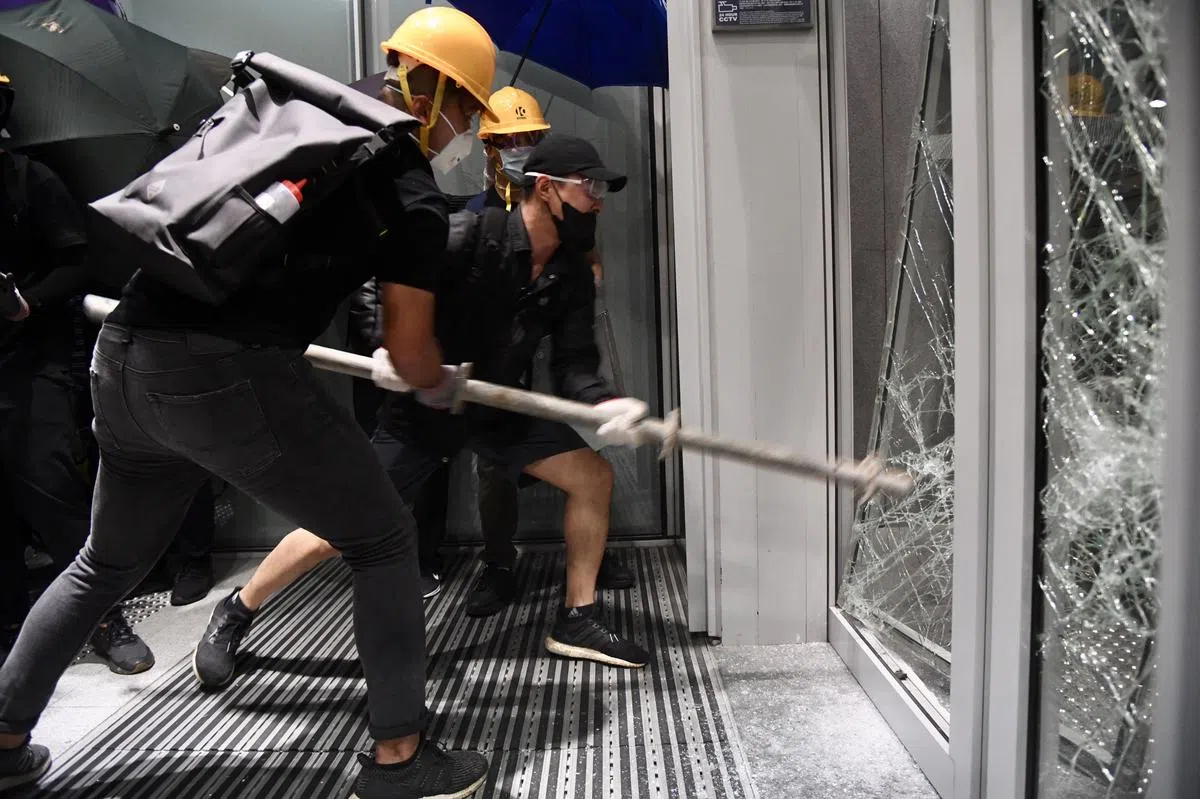 示威者以铁支、铁笼车等器具破坏立法会玻璃门。（中通社） 