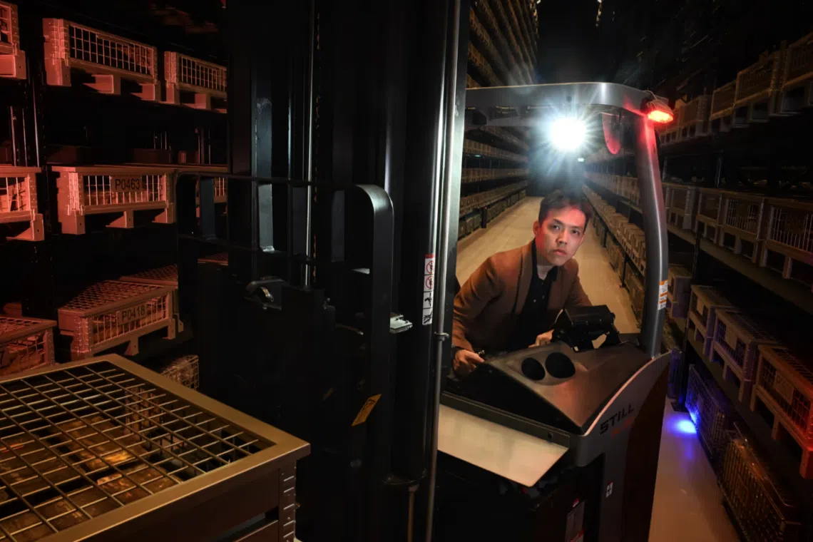 沈天杰需要把这些贵金属人工搬运到铁箱里。这些堆垛机最高可升至12米，能承载达1000公斤的金属。