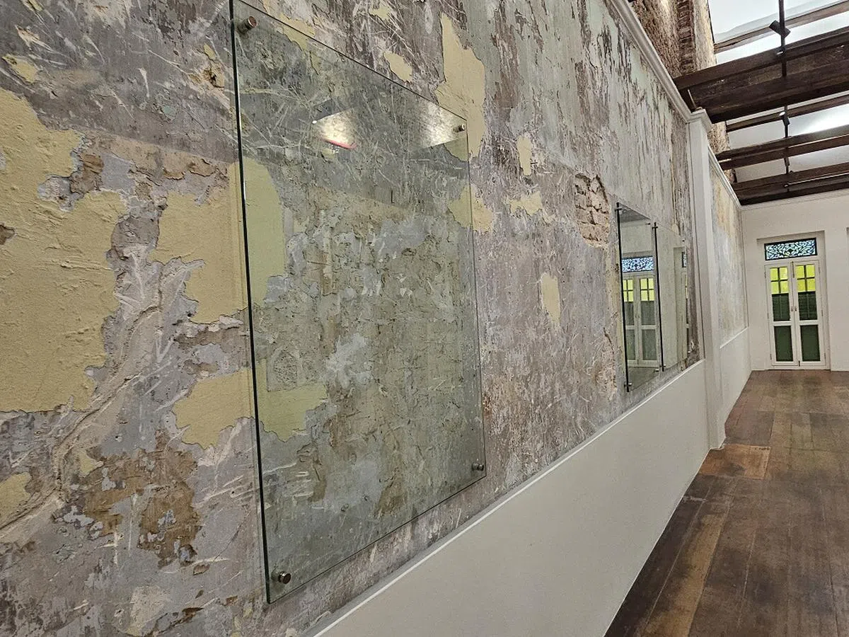 店屋三楼的部分墙壁安装了玻璃，以保留当年住户贴在墙上的报纸、一层层的油漆、石膏，以及曝露的砖块。（商业时报）