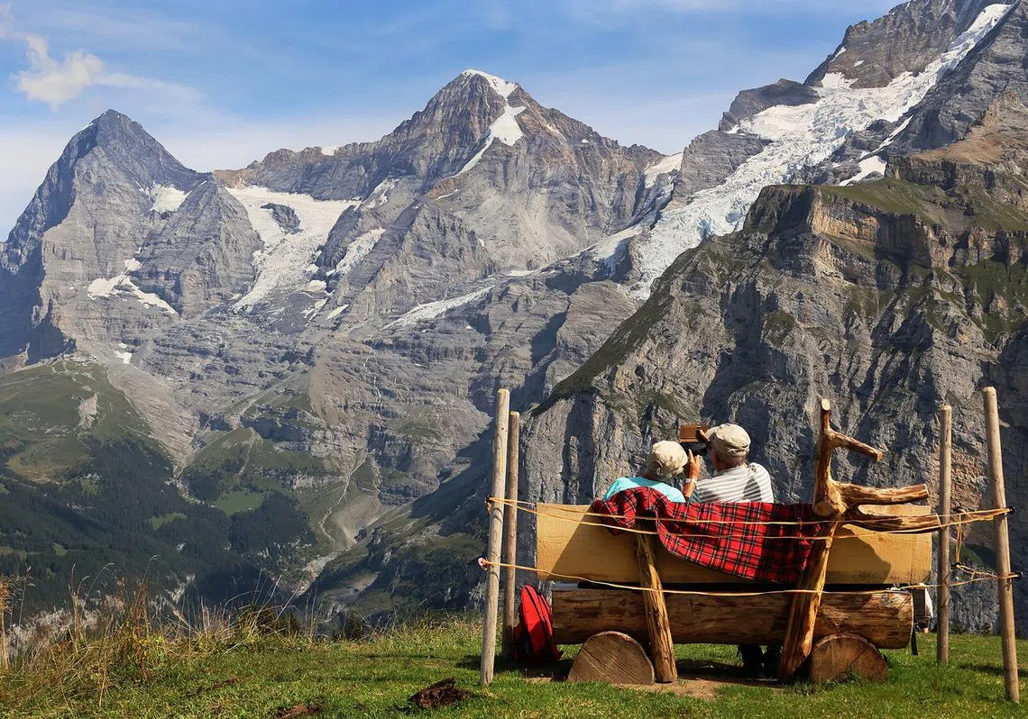 一对年长人士坐在瑞士米伦（Murren）山区的长凳上欣赏美景。（联合早报）