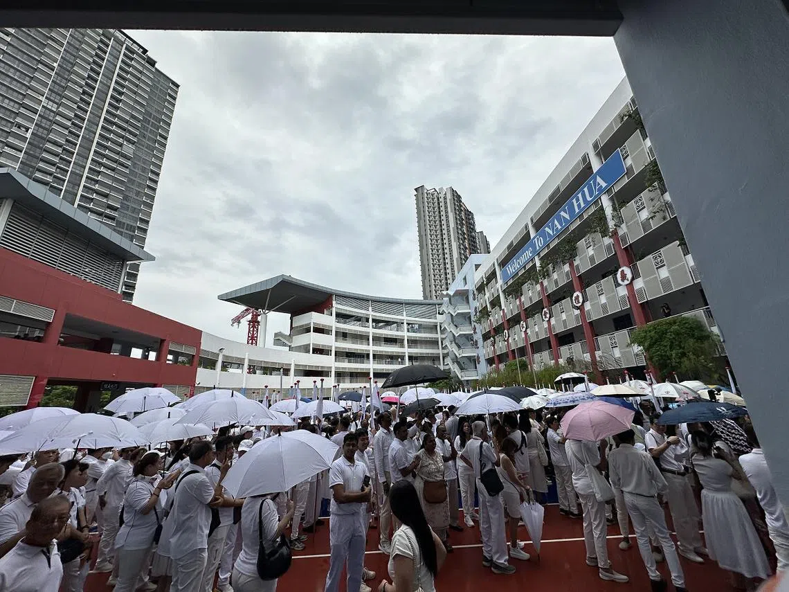 提名日早上天不作美，在南华中学提名站，各大政党支持者聚集操场撑伞等待顺利提名的候选人发言。（联合早报）