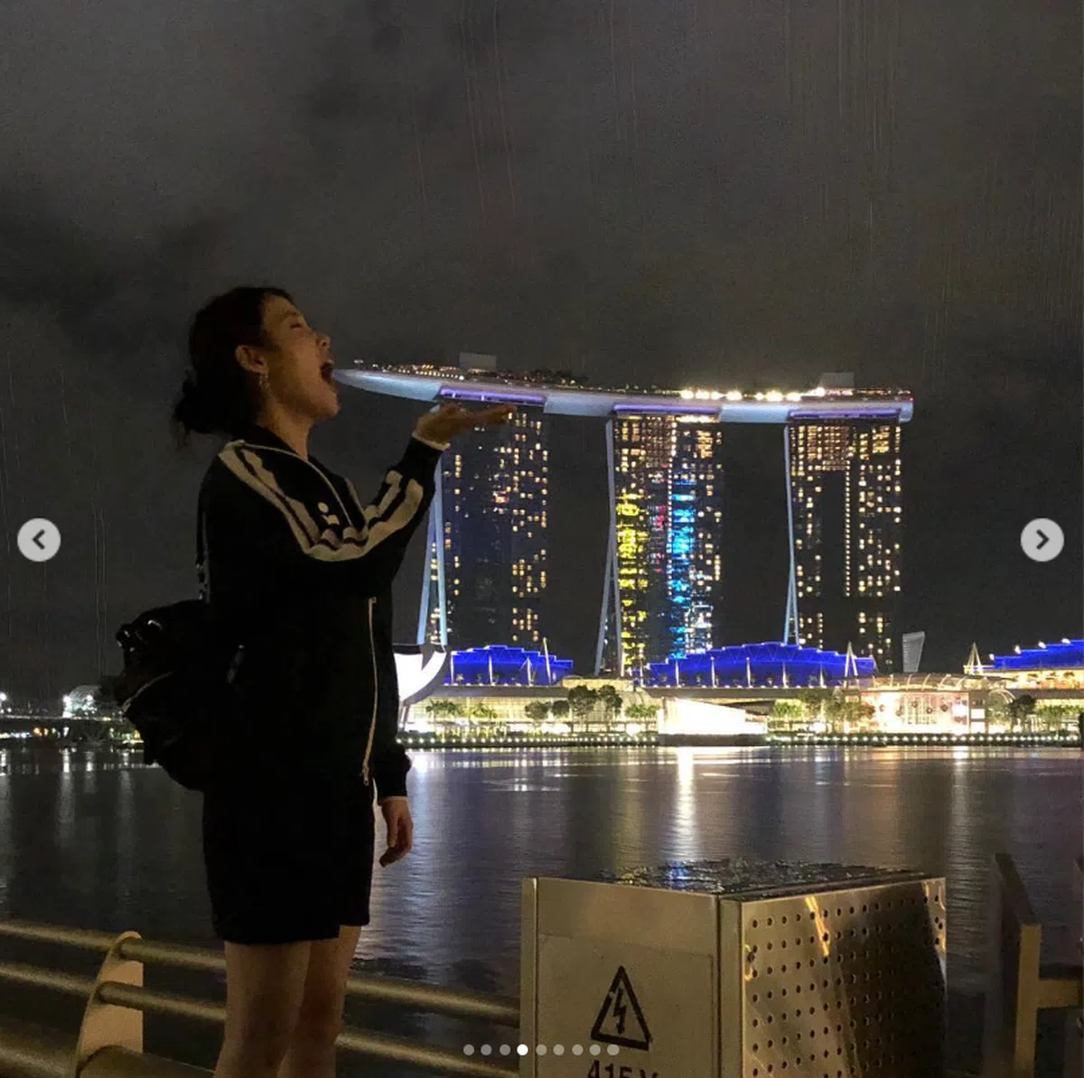 韩国女星李智恩（IU）假装吃着滨海湾金沙酒店的模样。（dlwlrma Instagram）