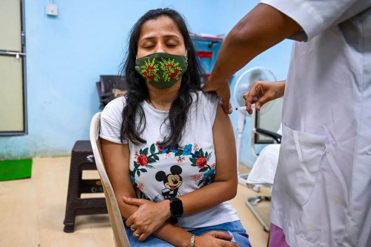  许多先进国已出现疫苗过剩的情况，但一些发展中国家却面对一剂难求的窘境，图为印度孟买接种疫苗的民众。（法新社） 