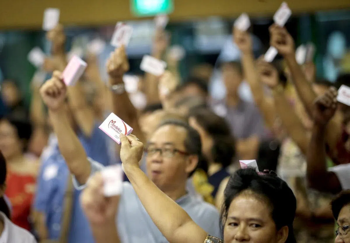  新加坡“立国一代”一起自豪地举起立国一代卡（Merdeka Generation card）。（联合早报） 
