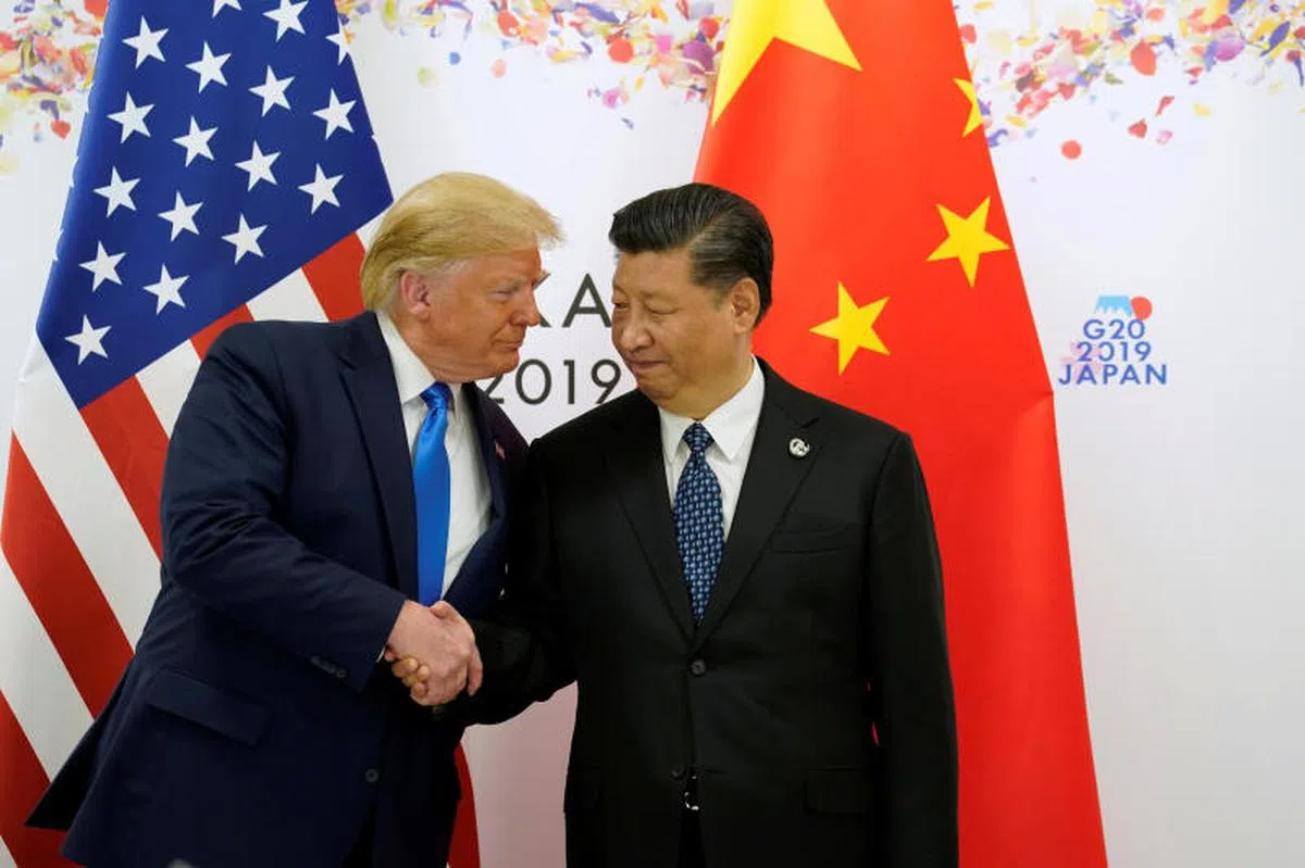  2019年6月，时任美国总统的特朗普（左）与中国国家主席习近平在日本大阪举行的在大阪20国集团（G20）峰会上握手合影。（路透社） 