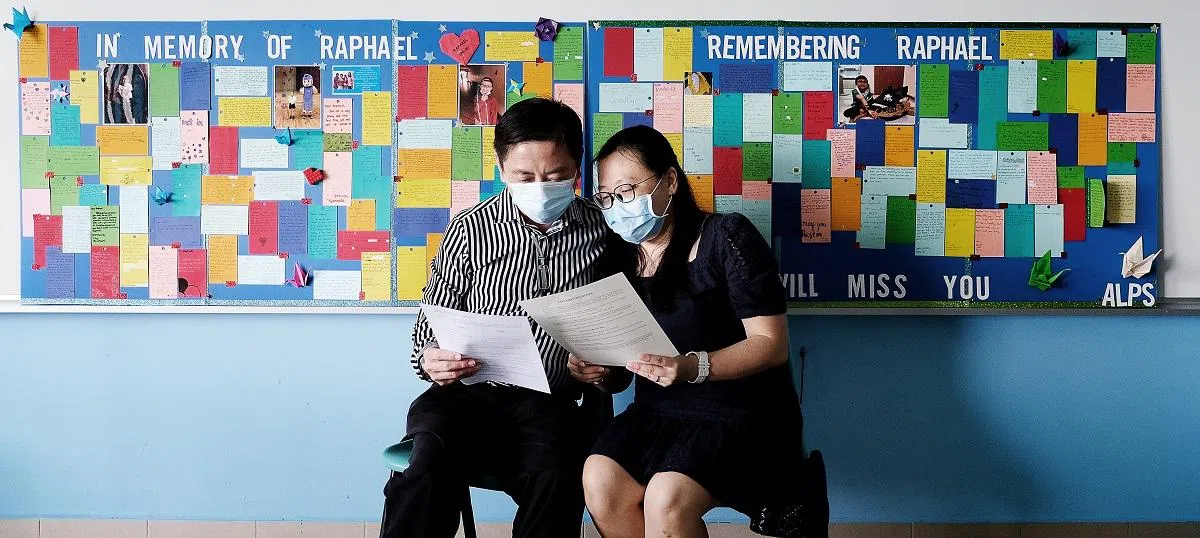  同学们在学校里为李安哲设立纪念的墙板。（联合早报） 