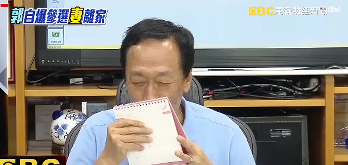  郭台铭采访时亲吻带有老婆照片的日历。（东森新闻） 