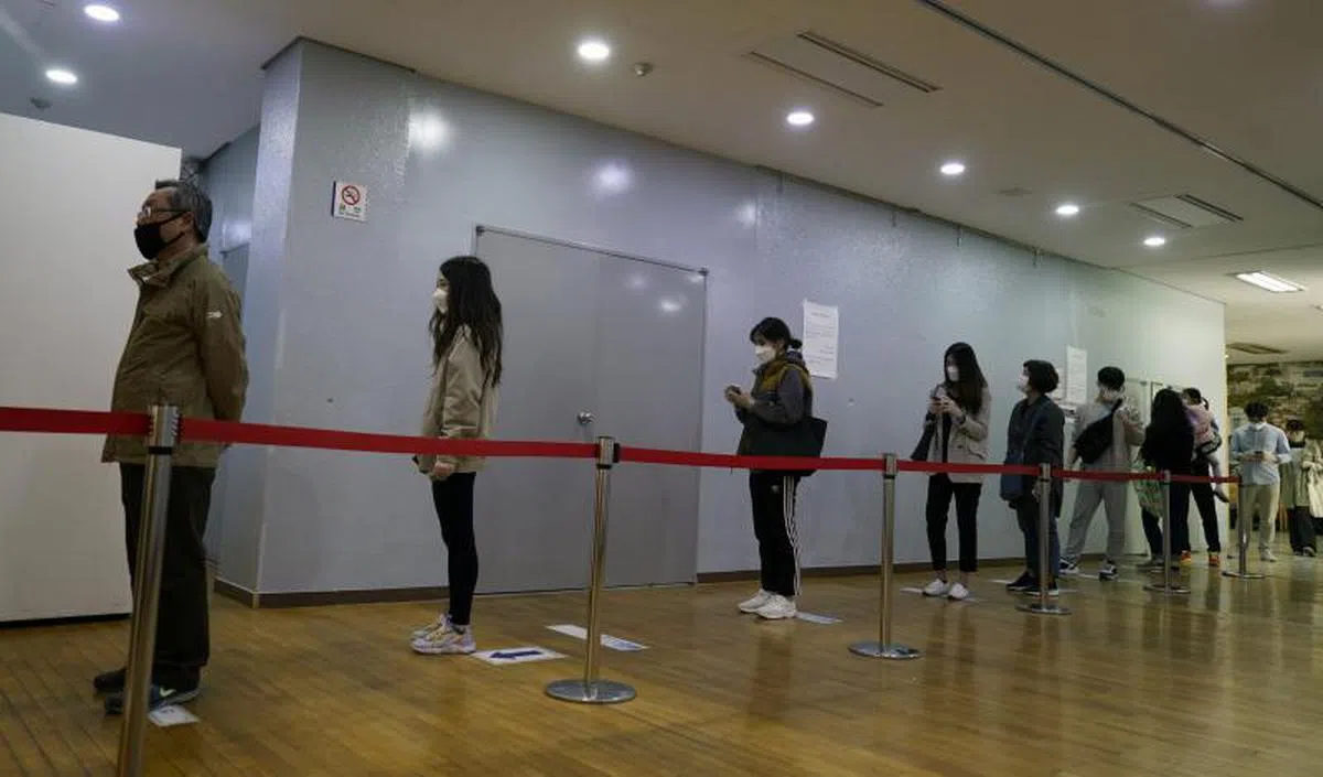  投票站地面贴有标示提醒选民保持距离。（中新社） 