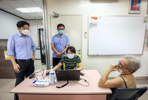 黄循财（左）和王乙康（右）在义顺视察流动疫苗接种小组的疫苗接种情况。（联合早报）