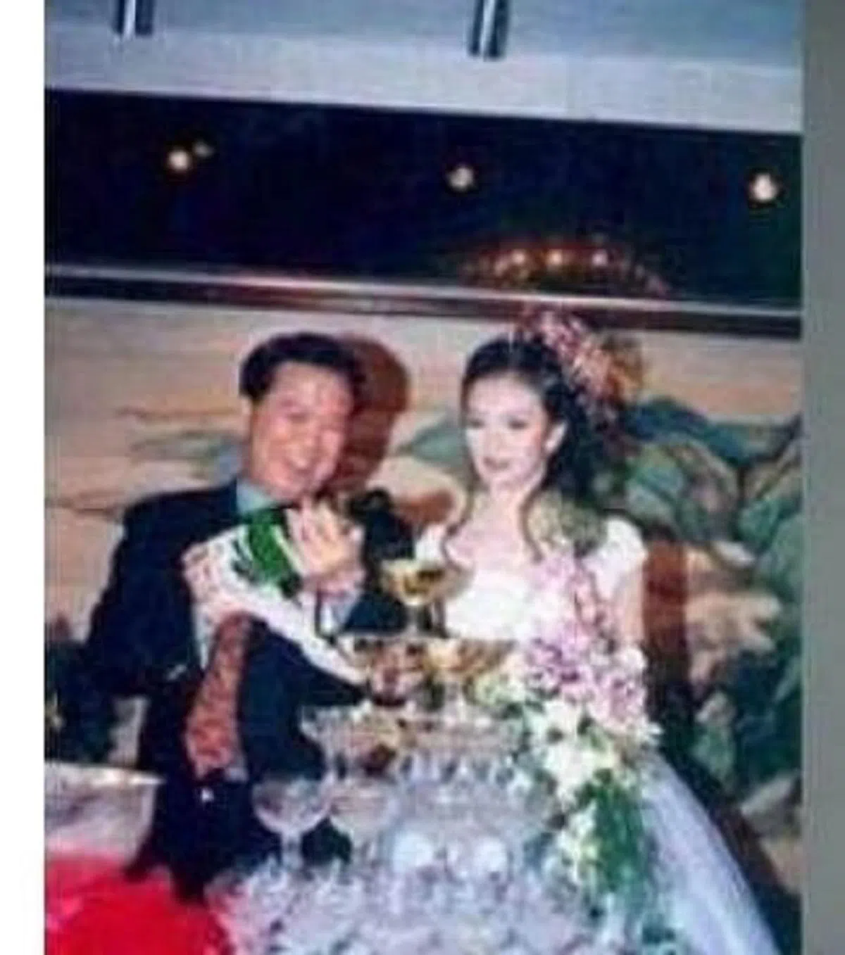  王志才和王艳在结婚宴席上倒香槟庆祝。（互联网） 