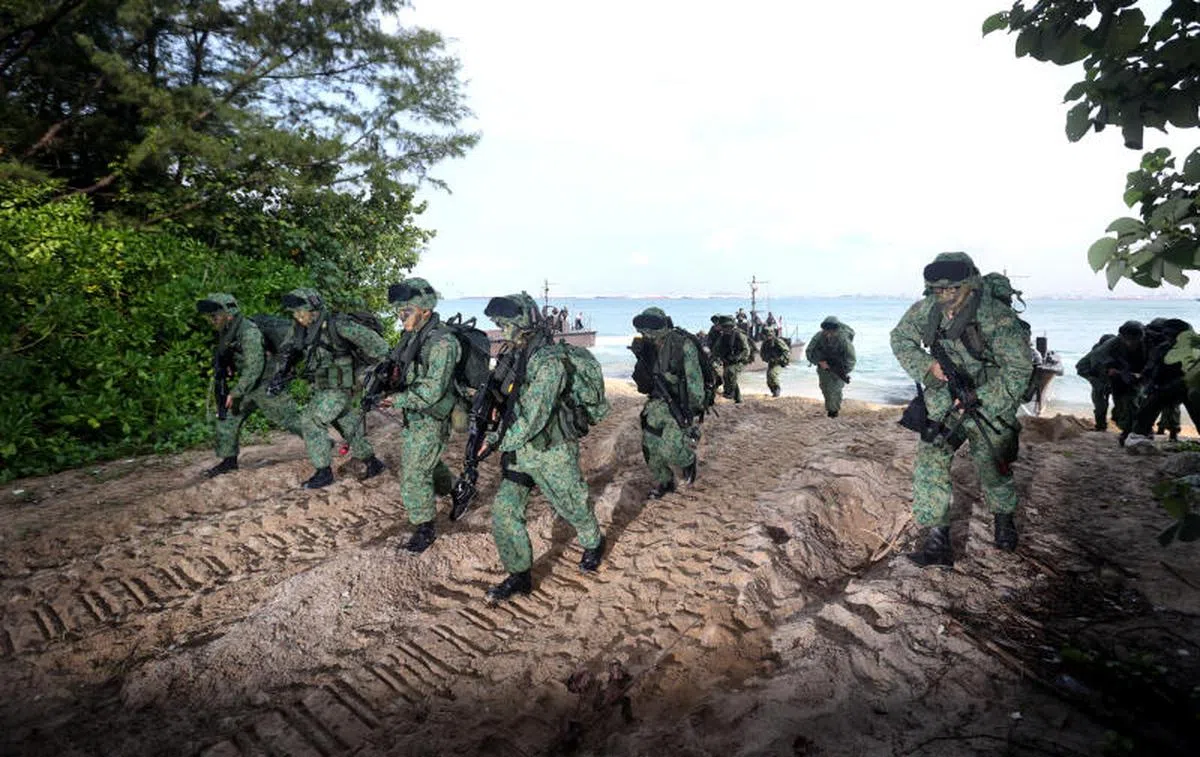 2014年4月24日，新加坡海陆空三军在苏东岛（Pulau Sudong）进行代号“金沙”的联合军演。演习共有约800人参与，包括450名武装部队第702精卫营战备军人。演习时，图中第702精卫营战备军人乘坐海军运输快艇，迅速抢滩登陆。（联合早报）