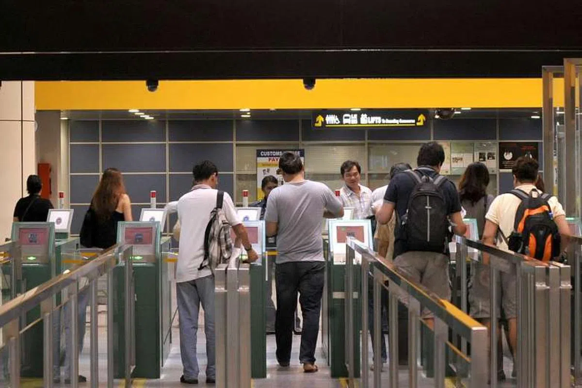  下了巴士后，这名学生居然跟着大家走，已经到了刷护照这一步了。（海峡时报） 