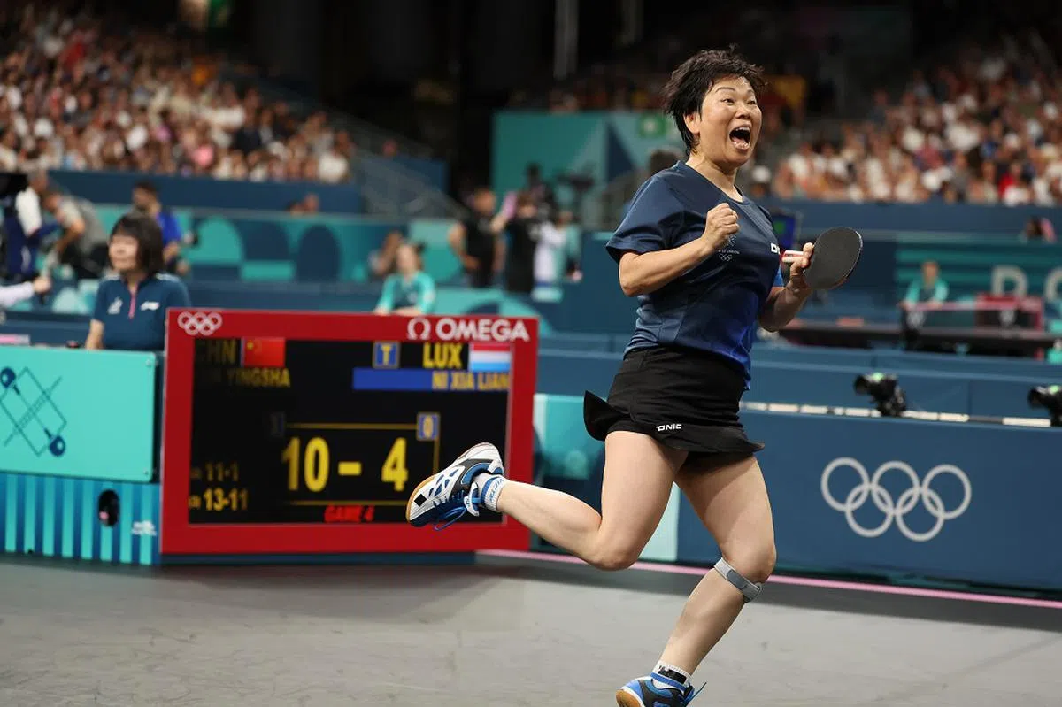 倪夏莲每次得分都会笑着向观众挥手致意，兴奋得像个少女。（联合早报）