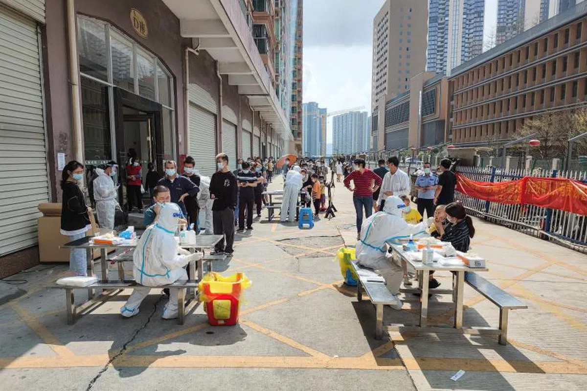 深圳3月13日宣布全市社区封闭管理、公交地铁停运，成为继陕西省会西安之后，又一个因冠病疫情而封城的千万级人口城市。图为深圳市民封城期间排队进行核酸检测。（法新社）