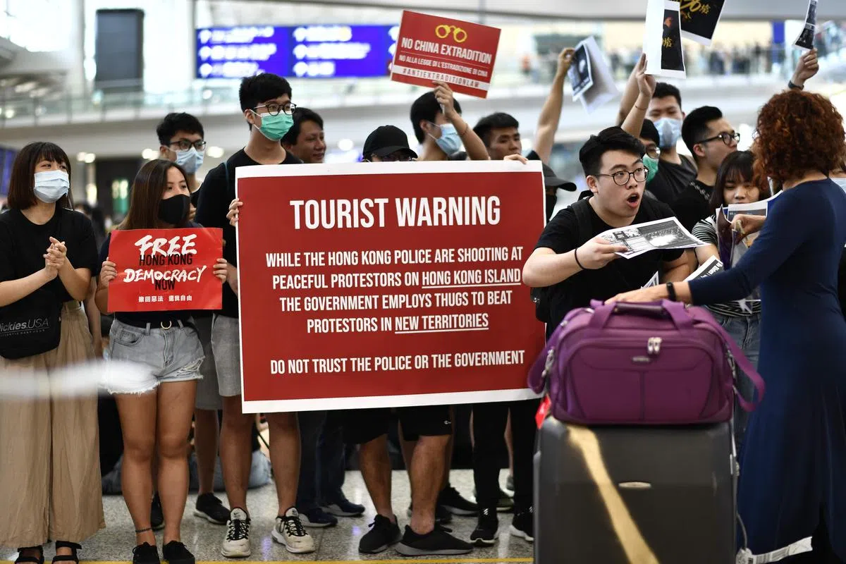  集会者向往来旅客派送传单。（法新社） 