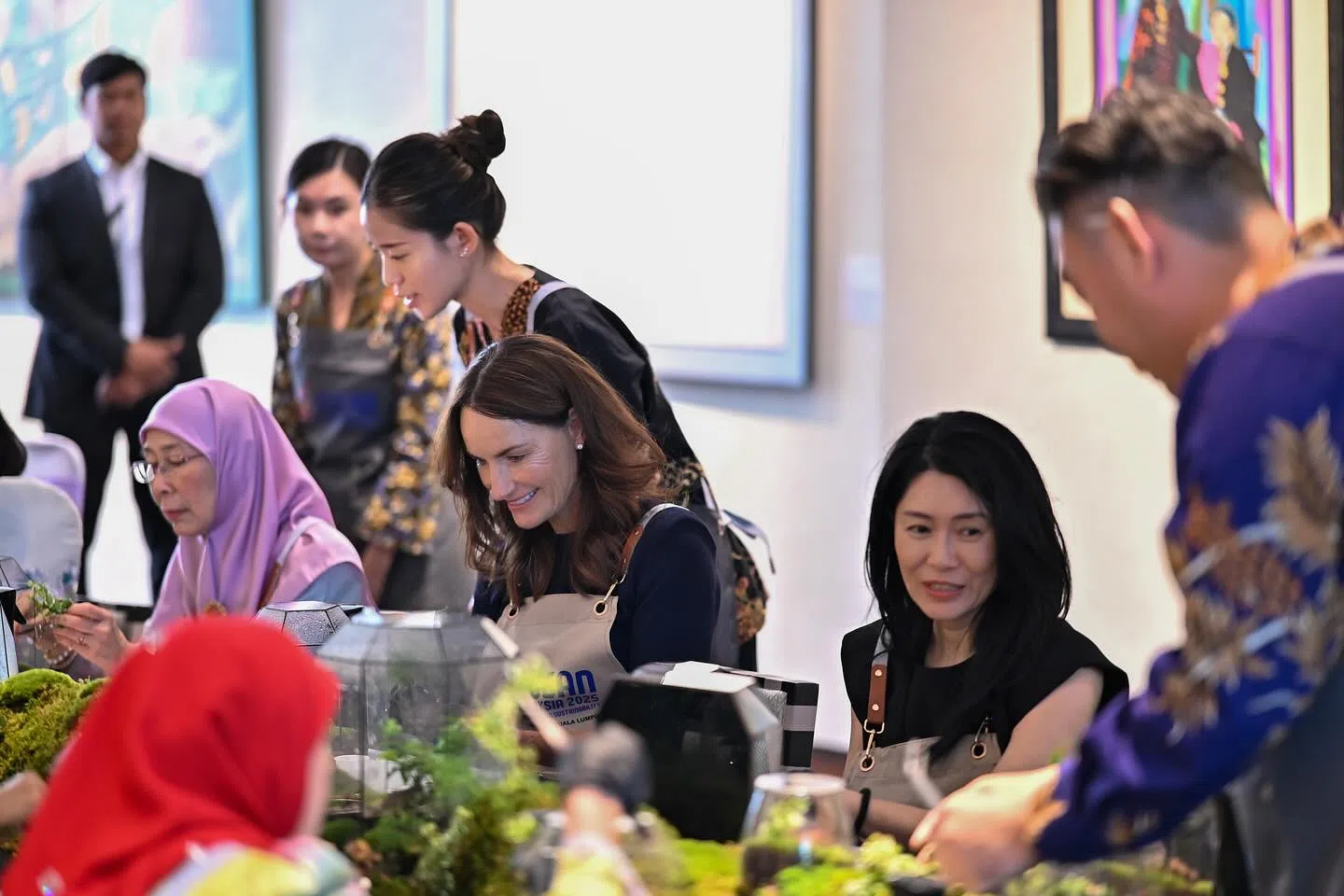 吕子蕊（右）和其他领导人夫人一同参加了制作生态瓶的活动。图中另外两位夫人分别为旺阿兹莎（左）及新西兰总理夫人阿曼达·拉克森。