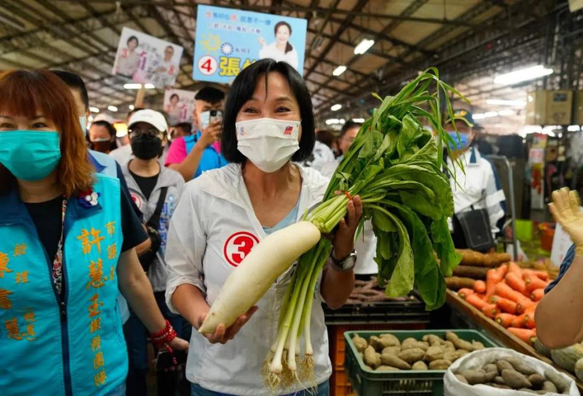 高雄市长候选人柯志恩手持蒜及萝卜拍照。（柯志恩提供）