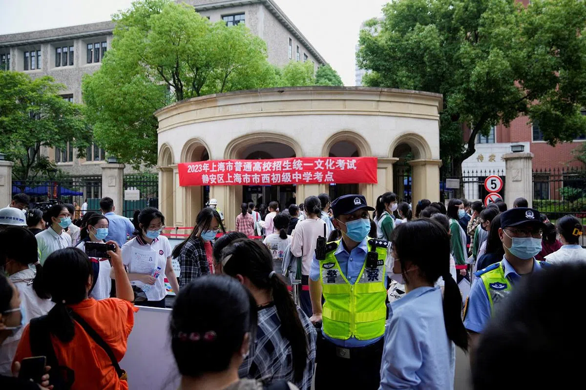 准备参加高考的学生在考点外排队，等待入场。（路透社）