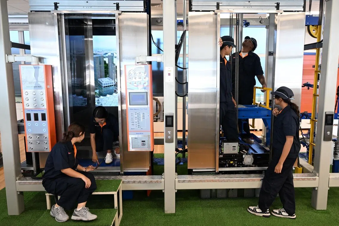 新加坡工艺教育学院学生在学习如何检修电梯。