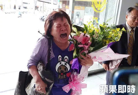 蒋月惠咬女警后，捧着鲜花登门警察局想要道歉，结果无人理会，觉得受到委屈，当场大哭。（台湾苹果日报）