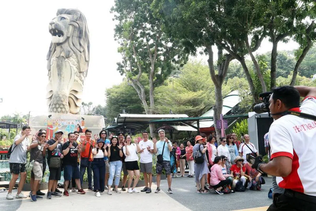  游客们争相与圣淘沙鱼尾狮合照。（联合早报） 