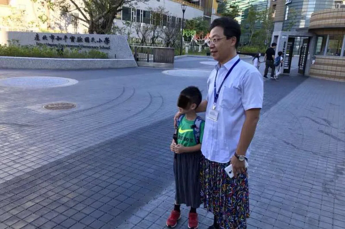  台北市和平实验国小的黄志顺校长（右一）穿上裙子，以行动支持教育理念。站在他旁边的是一位也穿上裙子的学校学生。（互联网） 